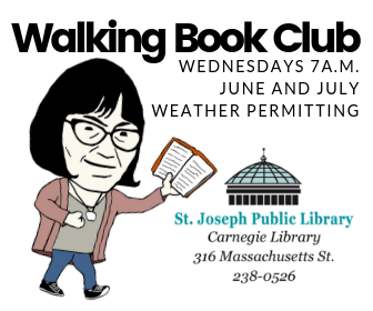 The librarian walking while holding a book. 