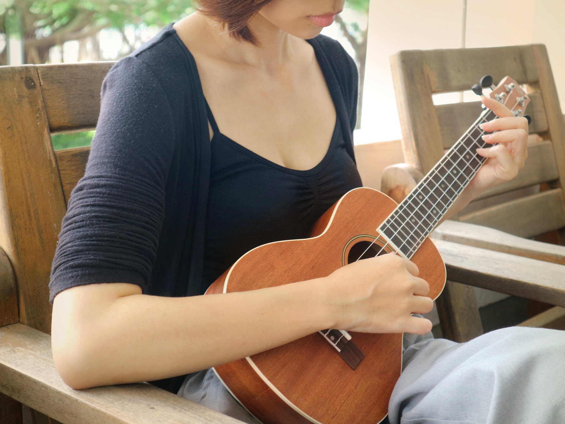 a young woman playing a ukulele