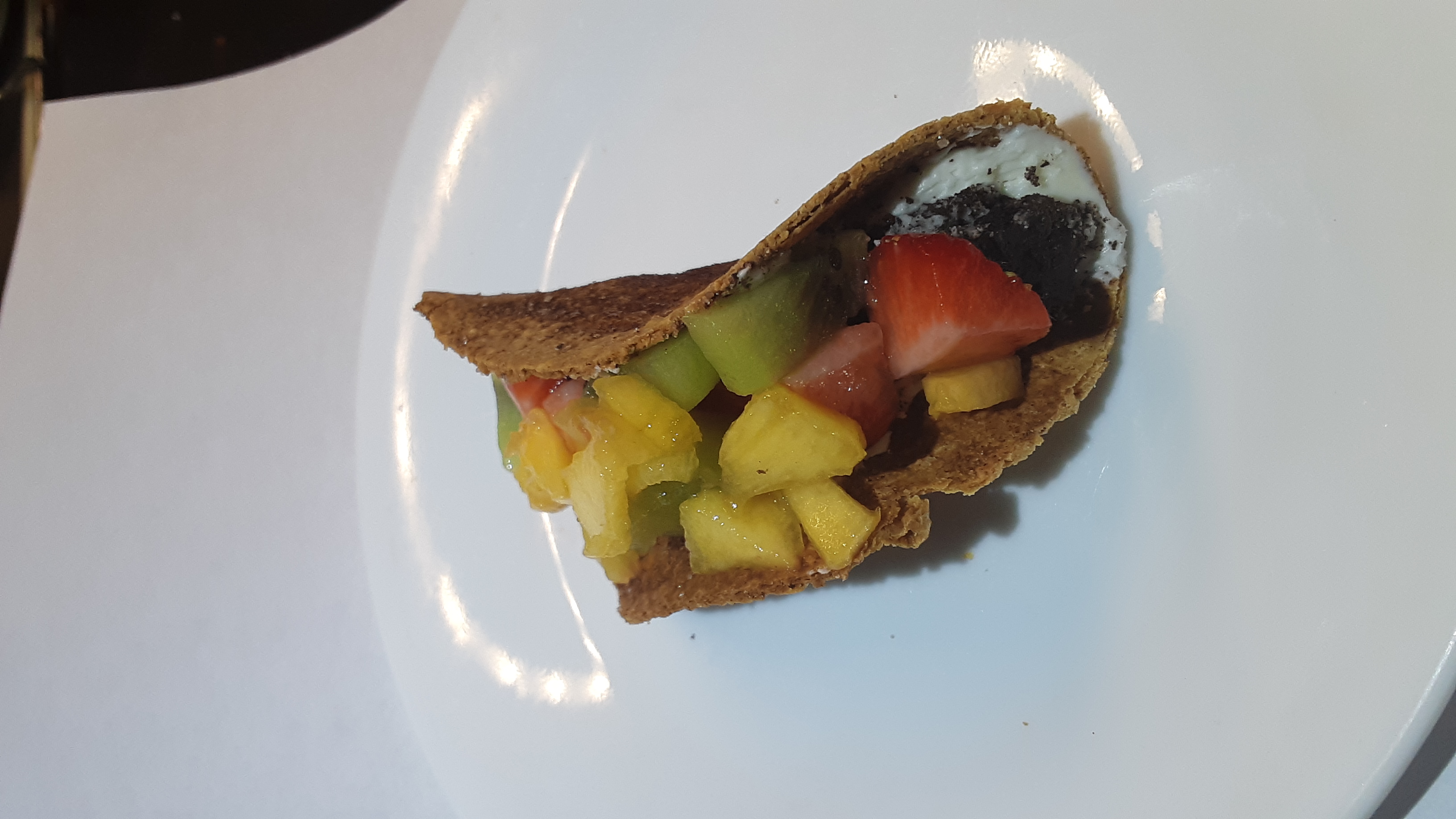 a dessert taco with fruit and frosting