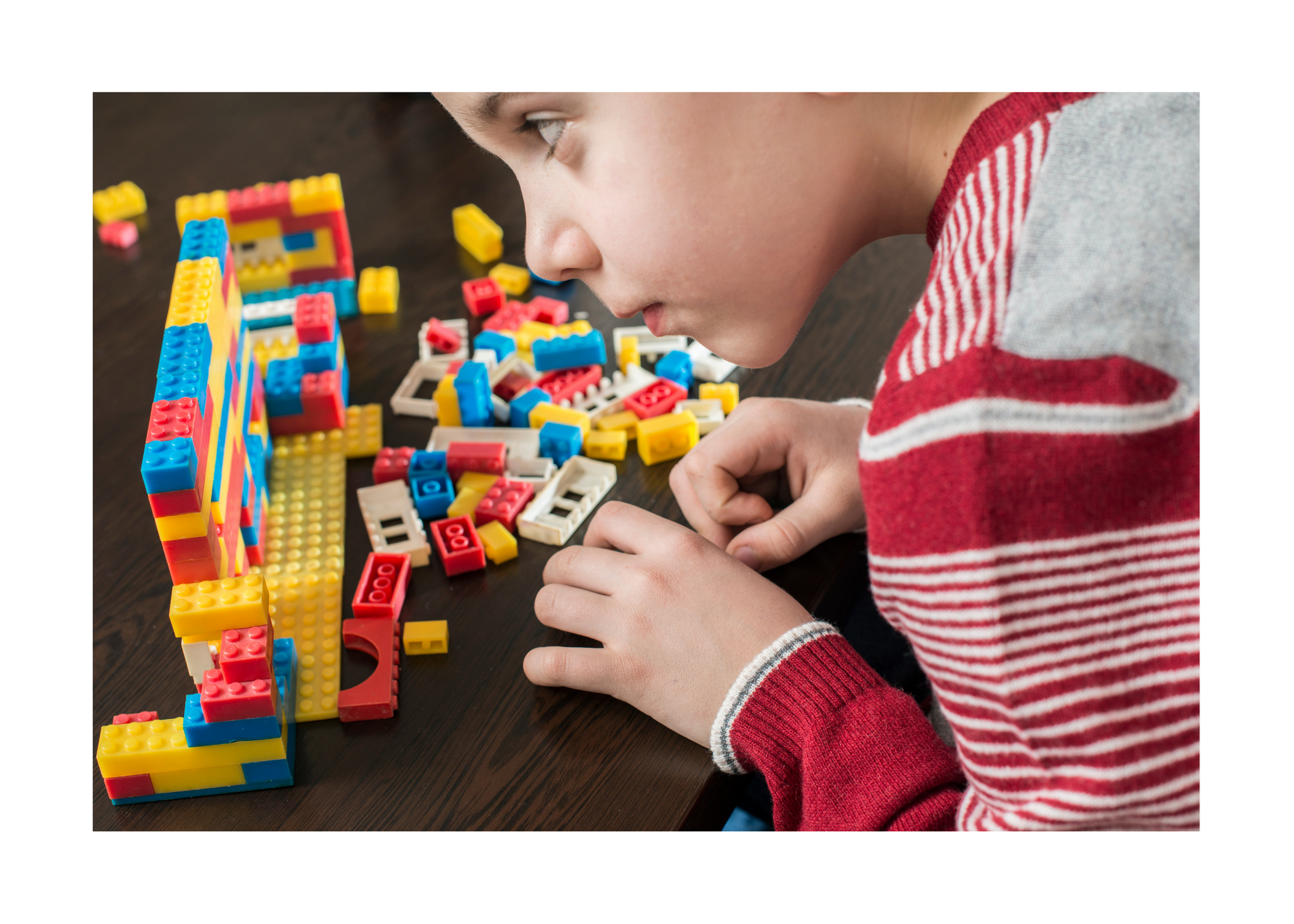 Child building with LEGO bricks.