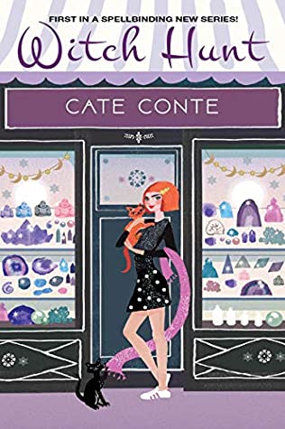 redheaded woman holding a ginger cat standing in front of a shop