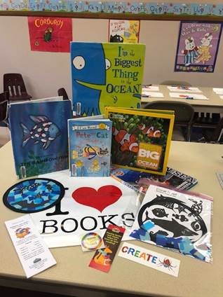 Collection of ocean-themed books and crafts displayed on a table. 