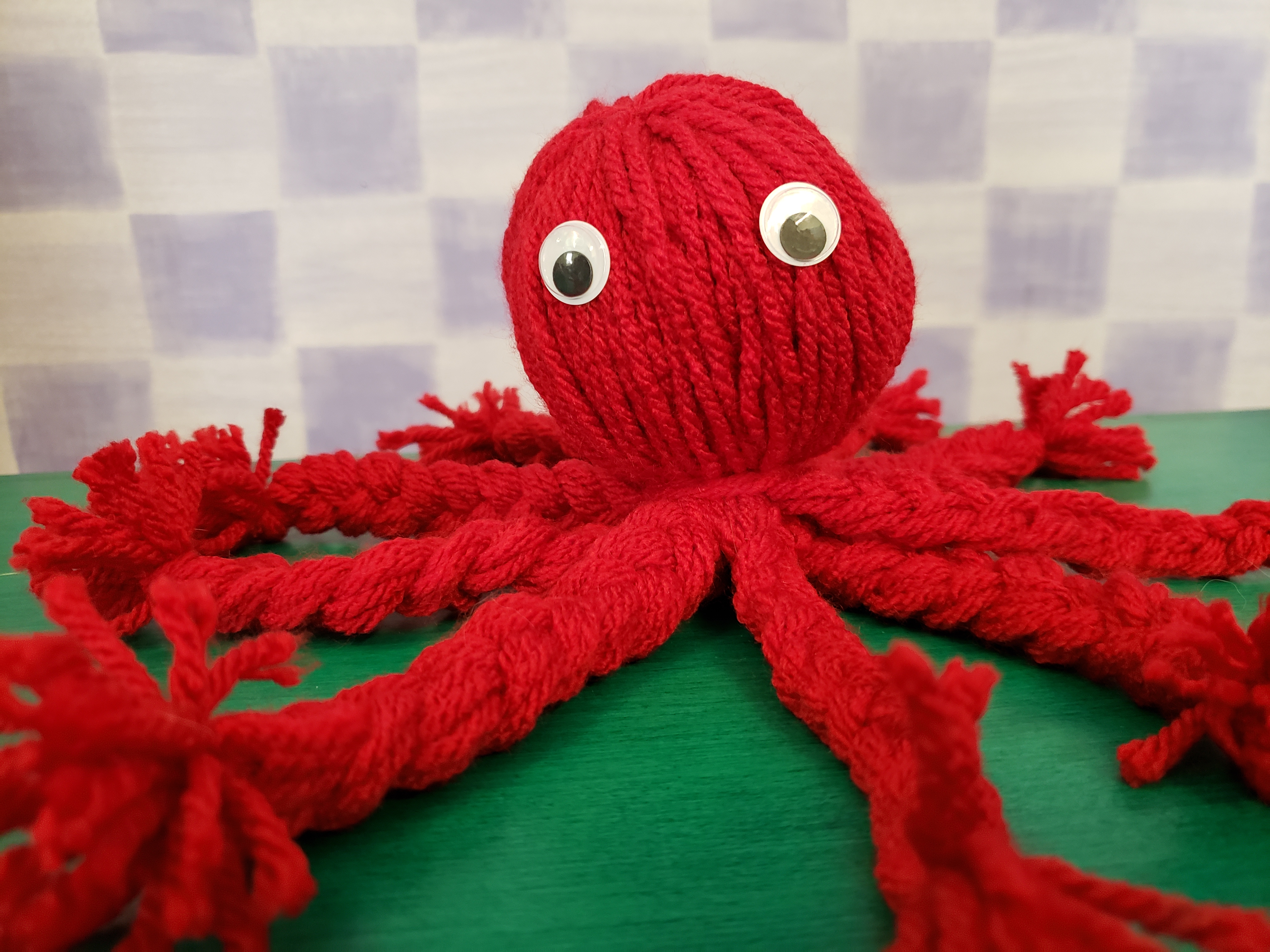 Image of red yarn octopus with braided legs