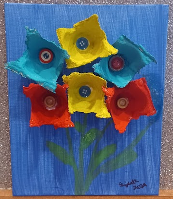 A colorful canvas with flowers made from egg carton cups and paint for May Day 2024 at the East Hills Library, May 1st at 4 PM.